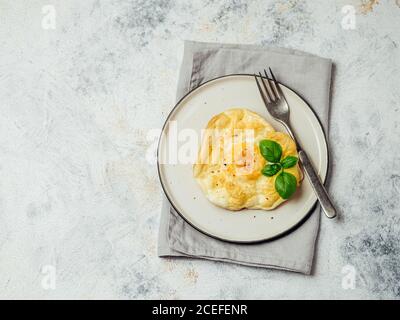 Fluffy Cloud Eggs. Trendy food - oven bake scrambled eggs with whipped egg white and whole yolk on plate Stock Photo