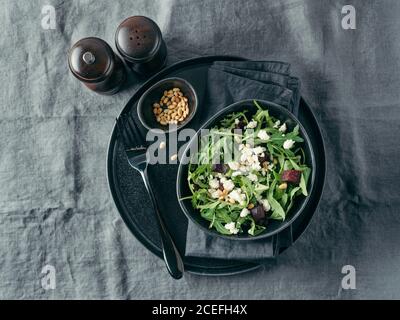 Beetroot, aragula and soft cheese salad over gray linen tablecloth. Top view or flat lay. Stock Photo
