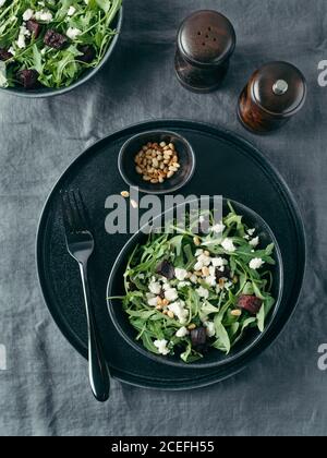 Beetroot, aragula and soft cheese salad over gray linen tablecloth. Top view or flat lay. Stock Photo