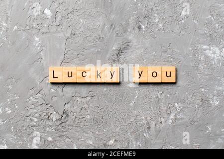 Lucky you word written on wood block. Lucky you text on cement table for your desing, Top view concept. Stock Photo
