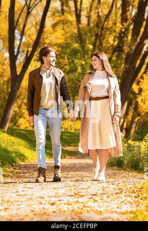 Full length portrait of young lovers in golden forest Stock Photo