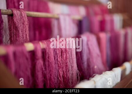 Close-up shades of pink colored threads hanging on wooden sticks in The Palm, Spain. Stock Photo