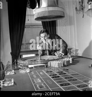 Comedian and television game show host Bob Monkhouse at home playing on his roulette table Stock Photo