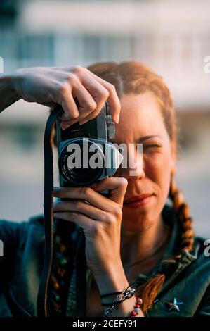 Pretty redhead girl with braids taking pictures. It is in the city of Madrid Spain. Stock Photo