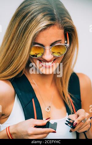 Young Woman touching backpack and laughing Stock Photo