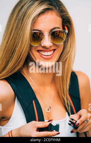 Young Woman touching backpack and laughing Stock Photo