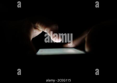 Close up of hacker hand stealing data from smart phone  Stock Photo