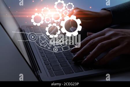 Connected gears on cyborg hand over working person Stock Photo