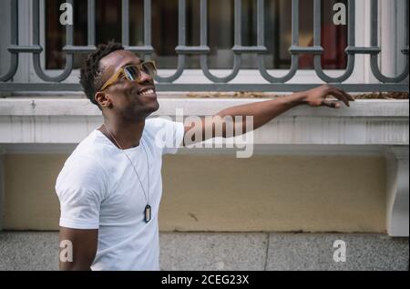 African man wearing white shirt and sunglasses posing. Stock Photo