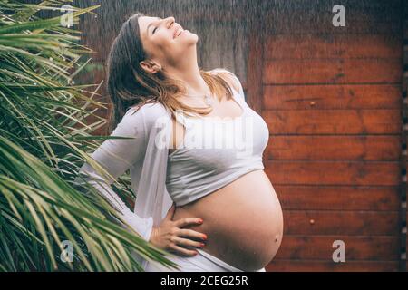Beautiful pregnant Woman posing in the rain. Stock Photo