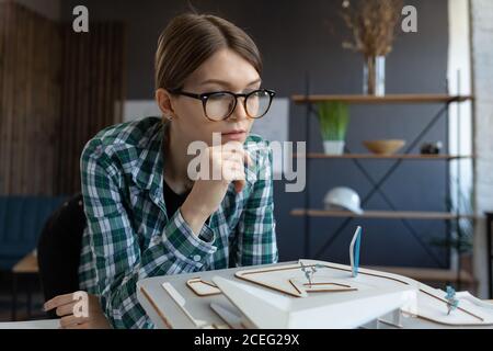 3d architect working in office with building 3D model. Engineer inspect building layout, searching new ideas for construction project. Beautiful woman Stock Photo
