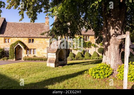Evening light on cottages beside the village green in the Cotswold village of Lower Slaughter, Gloucestershire UK Stock Photo
