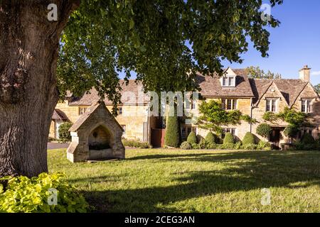 Evening light on cottages beside the village green in the Cotswold village of Lower Slaughter, Gloucestershire UK Stock Photo