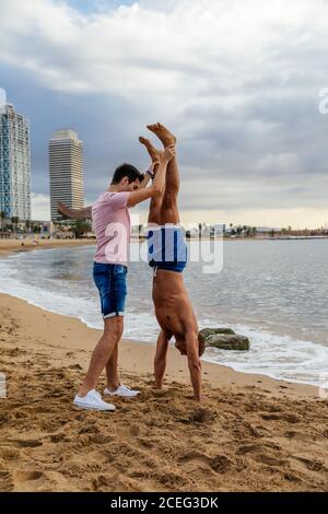 Two athletes do a handstand on the beach. Stock Photo
