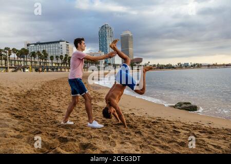 Two athletes do a handstand on the beach. Stock Photo