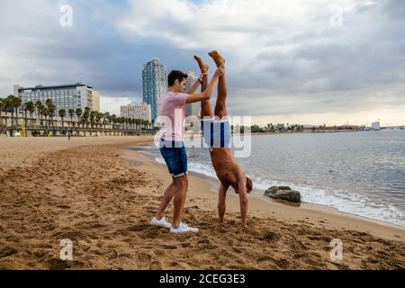 Two athletes do a handstand on the beach. Stock Photo