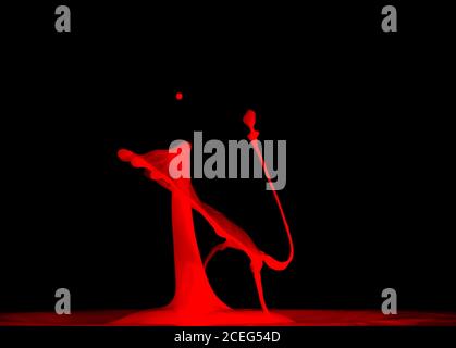 Closeup shot of splash of red liquid on black background Stock Photo