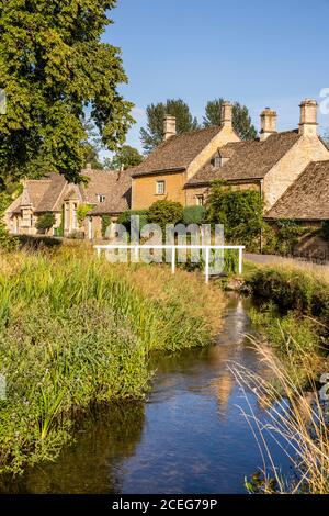 Evening light on stone cottages beside the River Eye in the Cotswold village of Lower Slaughter, Gloucestershire UK Stock Photo