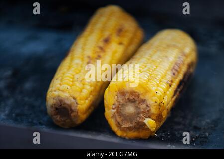 Close-up shot of delicious yellow corncobs cooked on grill and arranged on stall Stock Photo
