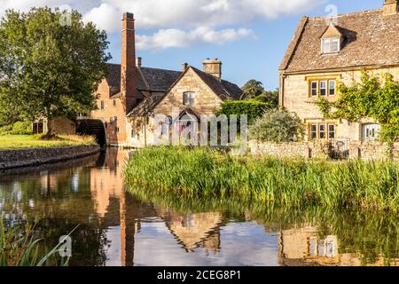 Evening light on the old mill and stone cottages beside the River Eye in the Cotswold village of Lower Slaughter, Gloucestershire UK Stock Photo