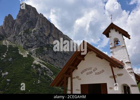 The small characteristic church of Passo Falzarego with Sass de Stria in the background Stock Photo