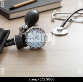Blood pressure measure equipment, Hypertension control. Medical stethoscope and sphygmomanometer on doctor office desk, closeup view. Stock Photo