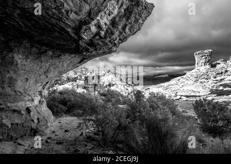 The rugged and weathered landscape surrounding the Stadsaal Caves in the Cederberg Mountains of South Africa in Monochrome. Stock Photo