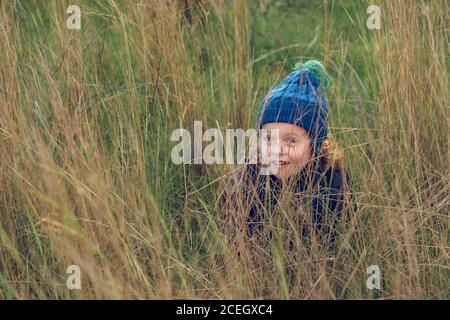 Cheerful little boy sitting in grass Stock Photo