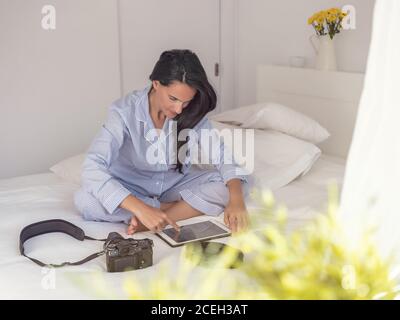 Young Woman sitting on bed Stock Photo