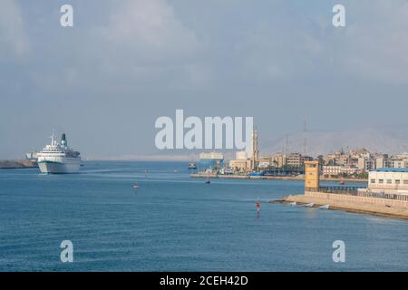 Egypt, Suez Canal. Ships entering the Suez Canal with mosque in the distance. MS Albatross transiting the Suez Canal. Stock Photo