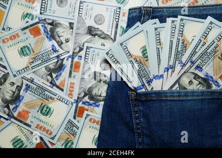 Several of banknotes hundred dollars of USA sticking out of his jeans pocket. dollars in the pocket of jeans. Stock Photo