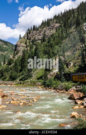 The Durango and Silverton Narrow Gauge Railroad travels along the Animas River as it passes through the San Juan Mountains  between Durango and Silver Stock Photo