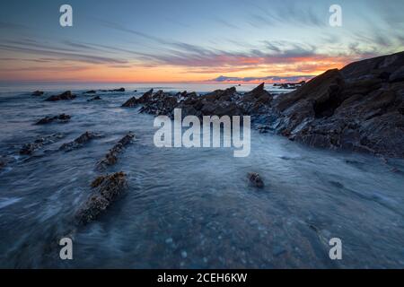 Sunset over Dollar Cove Gunwalloe off the Lizard Coast of Cornwall Stock Photo