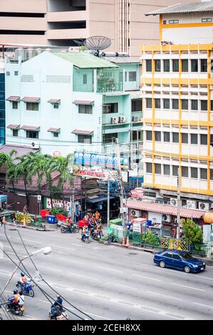 Looking down from Asoke Skytrain station onto Asoke Montri Rd. The alley with the entrance sign is the famous red light street called Soi Cowboy. Stock Photo
