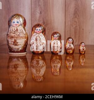 Five dolls on a brown wooden table and a texture on a wooden background Stock Photo