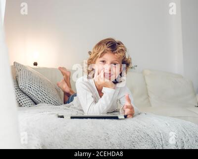 Cheerful boy using tablet of couch Stock Photo