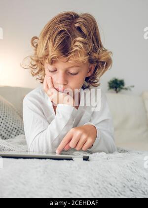 Cheerful boy using tablet of couch Stock Photo