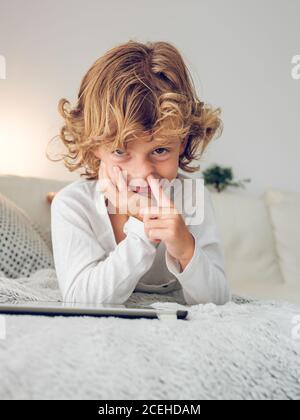 Cheerful boy using tablet of couch Stock Photo
