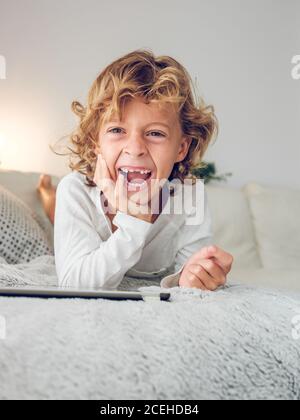 Cheerful boy using tablet of couch Stock Photo