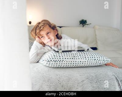 Cute boy with tablet on sofa Stock Photo