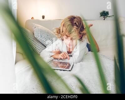 boy using tablet on sofa Stock Photo