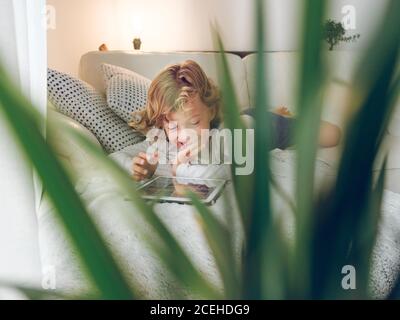 boy using tablet on sofa Stock Photo