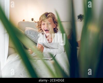 boy using tablet on sofa Stock Photo