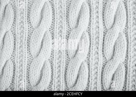 Sweater or scarf texture large knitting. Knitted jersey background with a relief pattern. Braids in knitting. Wool hand-knitted or machine knitting pa Stock Photo