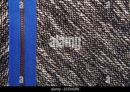 Grey tweed like texture, gray wool pattern with blue zipper, textured salt and pepper style black and white melange upholstery. Fabric background copy Stock Photo