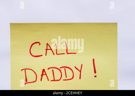 Call daddy handwriting text close up isolated on yellow paper with copy space. Stock Photo