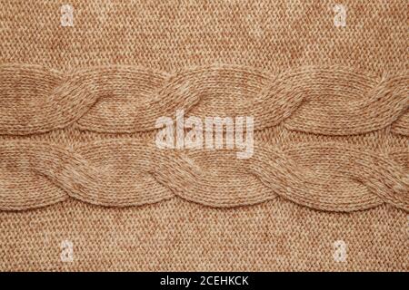 Wool sweater texture close up. Knitted jersey background with a relief pattern. Braids in machine knitting pattern Stock Photo