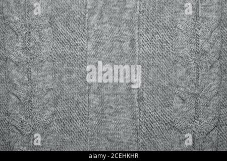 Wool sweater texture close up. Knitted jersey background with a relief pattern. Braids in machine knitting pattern Stock Photo
