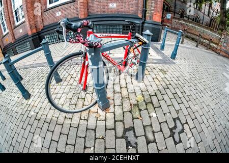 Wide angle fisheye view of an expensive racing bicycle locked to an outside bike rack in a quiet street in the city of Norwich, Norfolk. Stock Photo