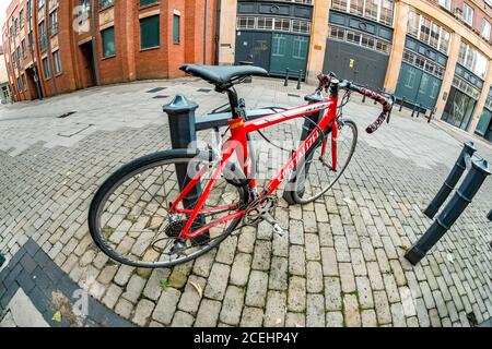 Wide angle fisheye view of an expensive drop handle racing bicycle locke to an outdoor bike rack in the city of Norwich in Norfolk Stock Photo